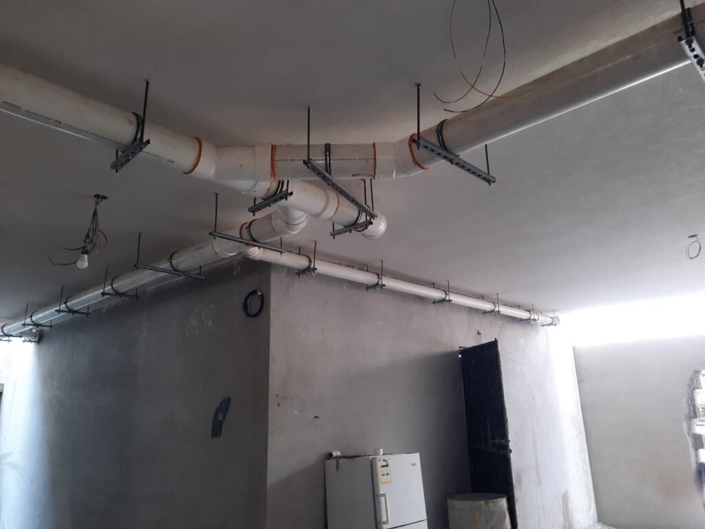Pipes hung from the concrete slab, installed before the gypsum ceiling is closed