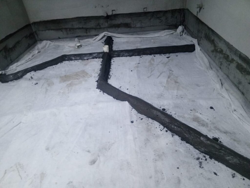 Drain pipes laid on a waterproofed floor and protected with cement