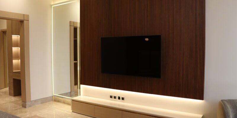 Smart home technology in a luxury villa: TV wall with integrated LED lighting, wooden paneling and concealed wiring