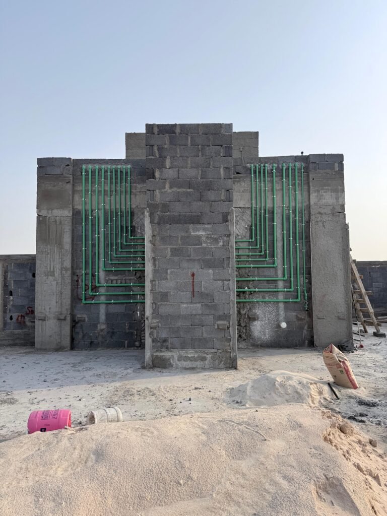 Water supply pipes routed inside a block wall before it is closed