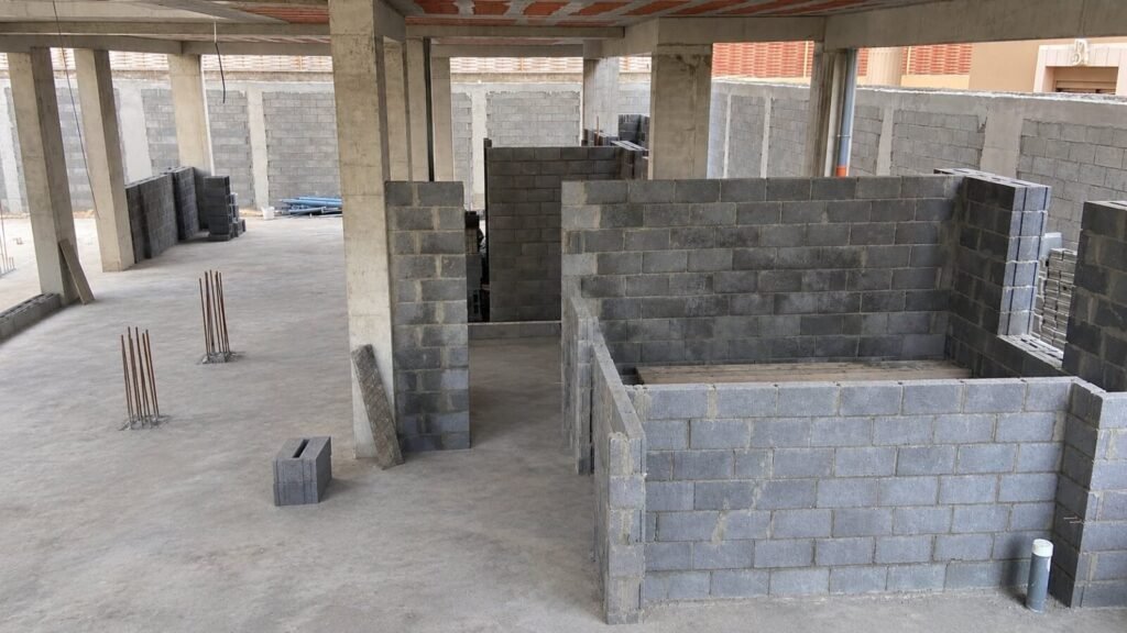 Concrete block walls going up on a villa ground floor, between the concrete columns