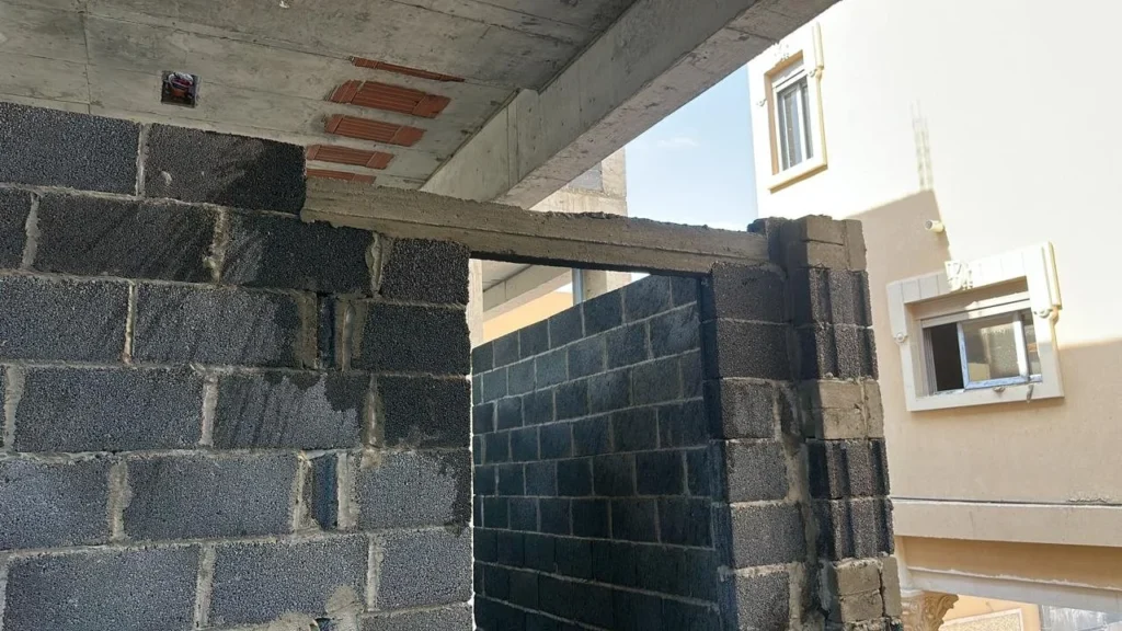 Concrete lintel cast in place over a wide opening in a block wall